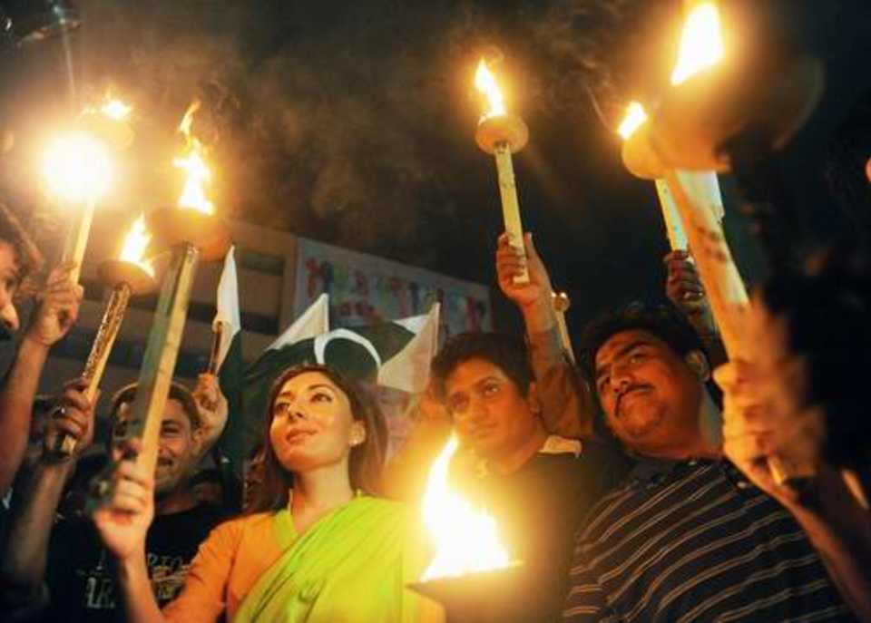 Pakistani fans hold torches during a rally to celebrate the team's win in the World Twenty20