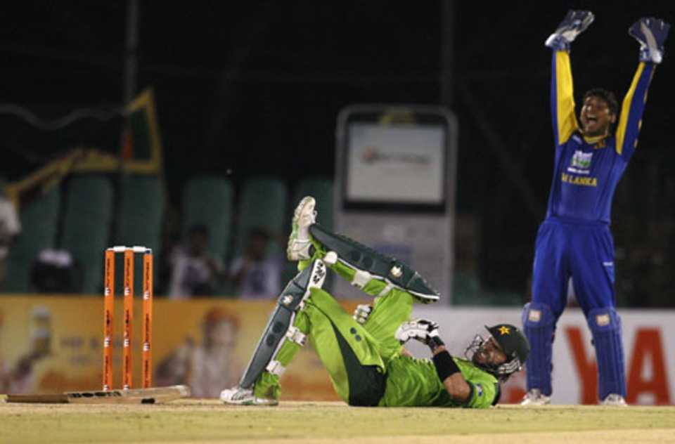 Kumar Sangakkara lets out a loud appeal, while Shahid Afridi struggles with cramps