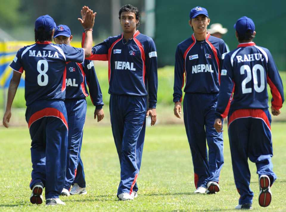 Paras Khadka celebrates with his team after picking a wicket