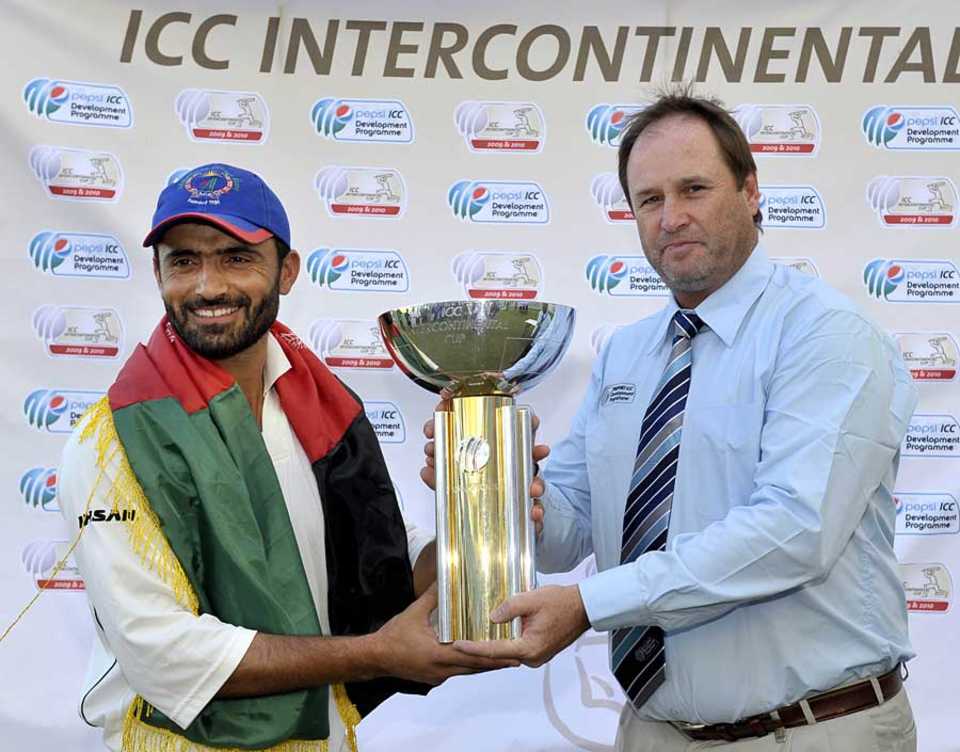Nawroz Mangal is handed the trophy by ICC's Richard Done