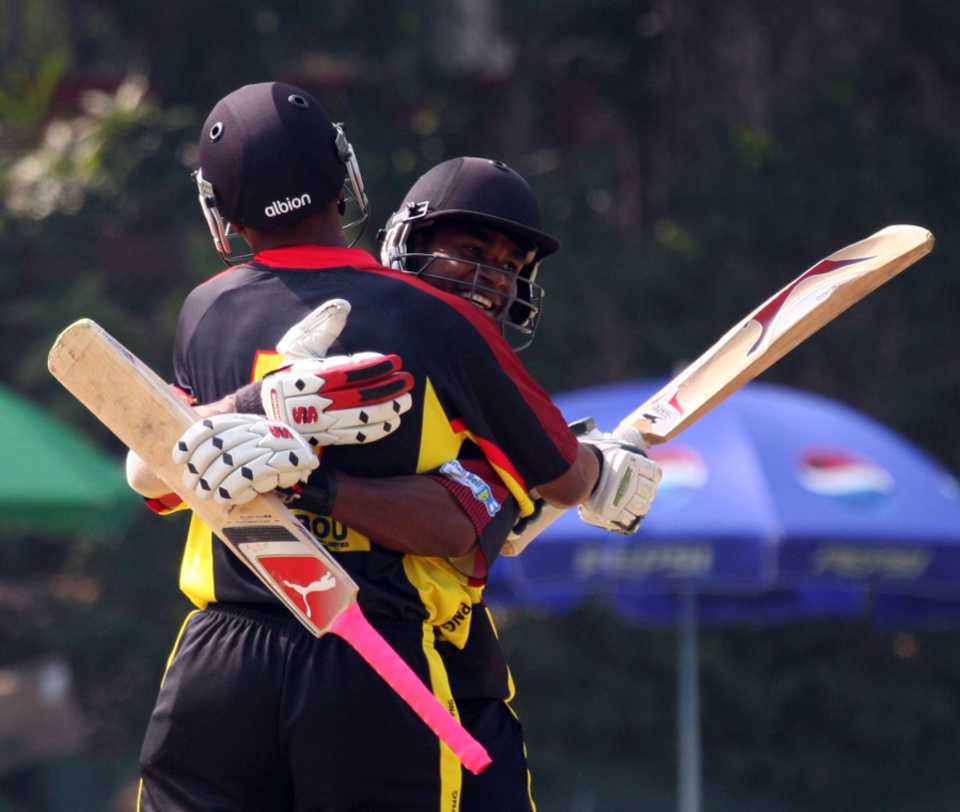 Tony Ura and Chris Amini embrace after securing Papua New Guinea's nine-wicket win