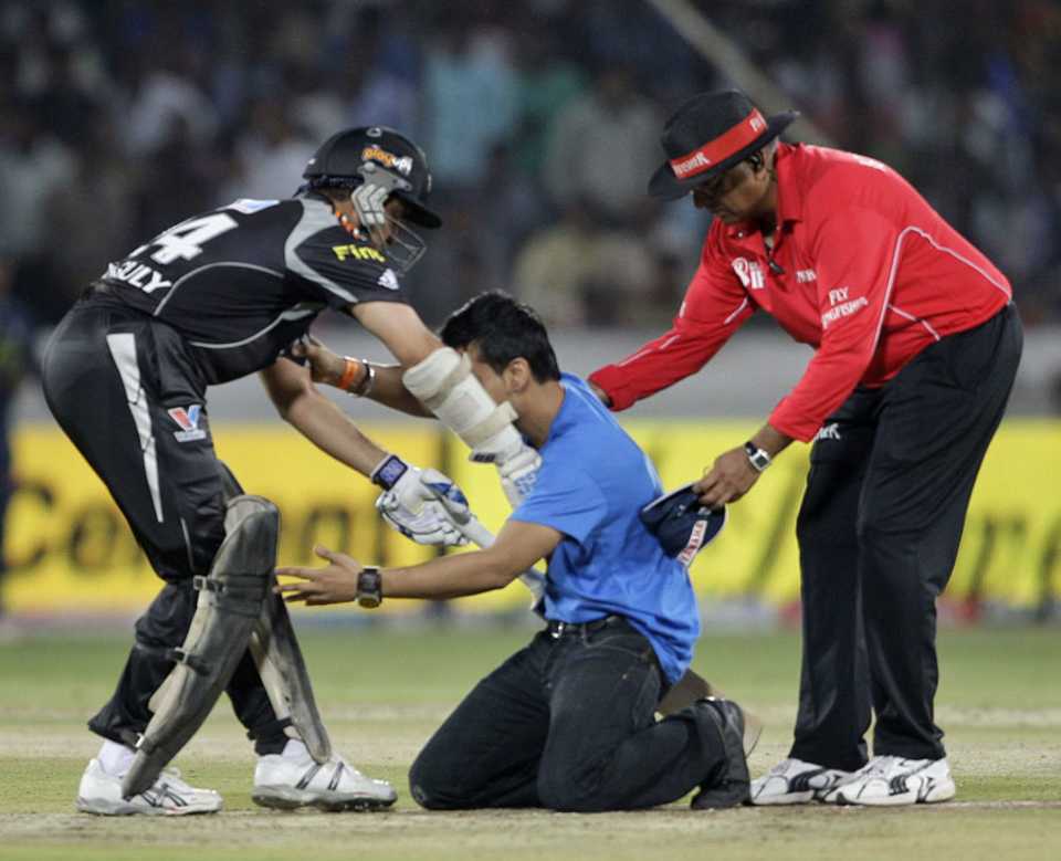 Sourav Ganguly tries to stop a fan who jumped the fence to touch his feet