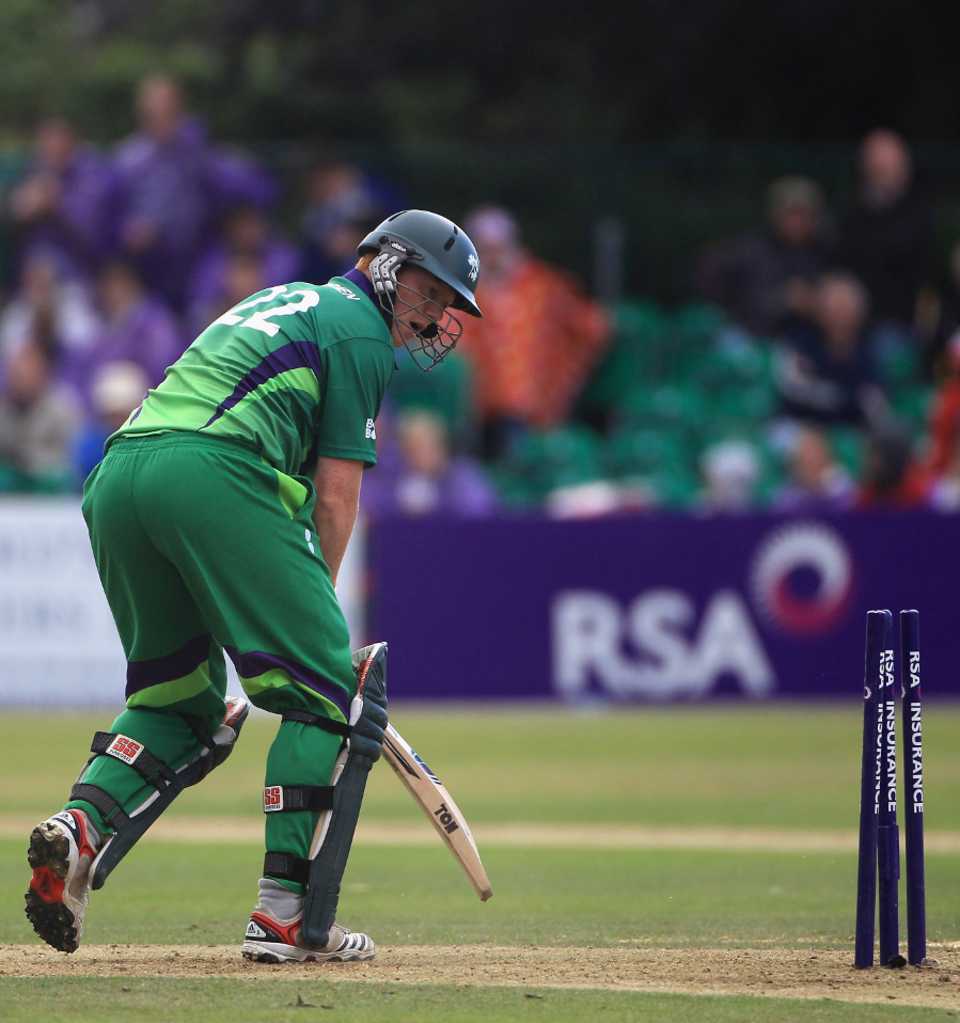 Kevin O'Brien looks back to see his stumps disturbed