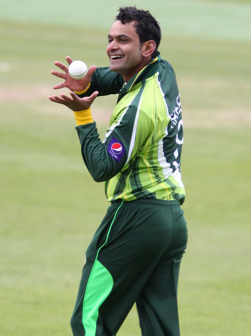 Mohammad Hafeez has a laugh before bowling a ball