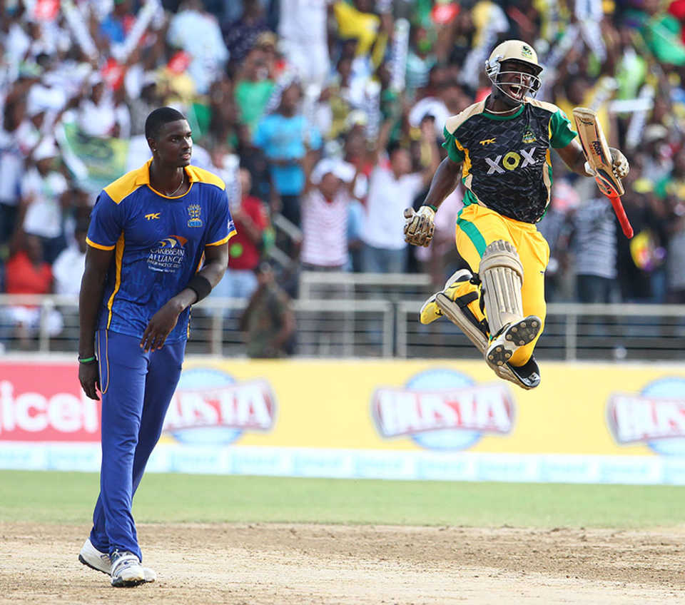 Andre Russell celebrates Jamaica Tallawahs' victory as Jason Holder looks on