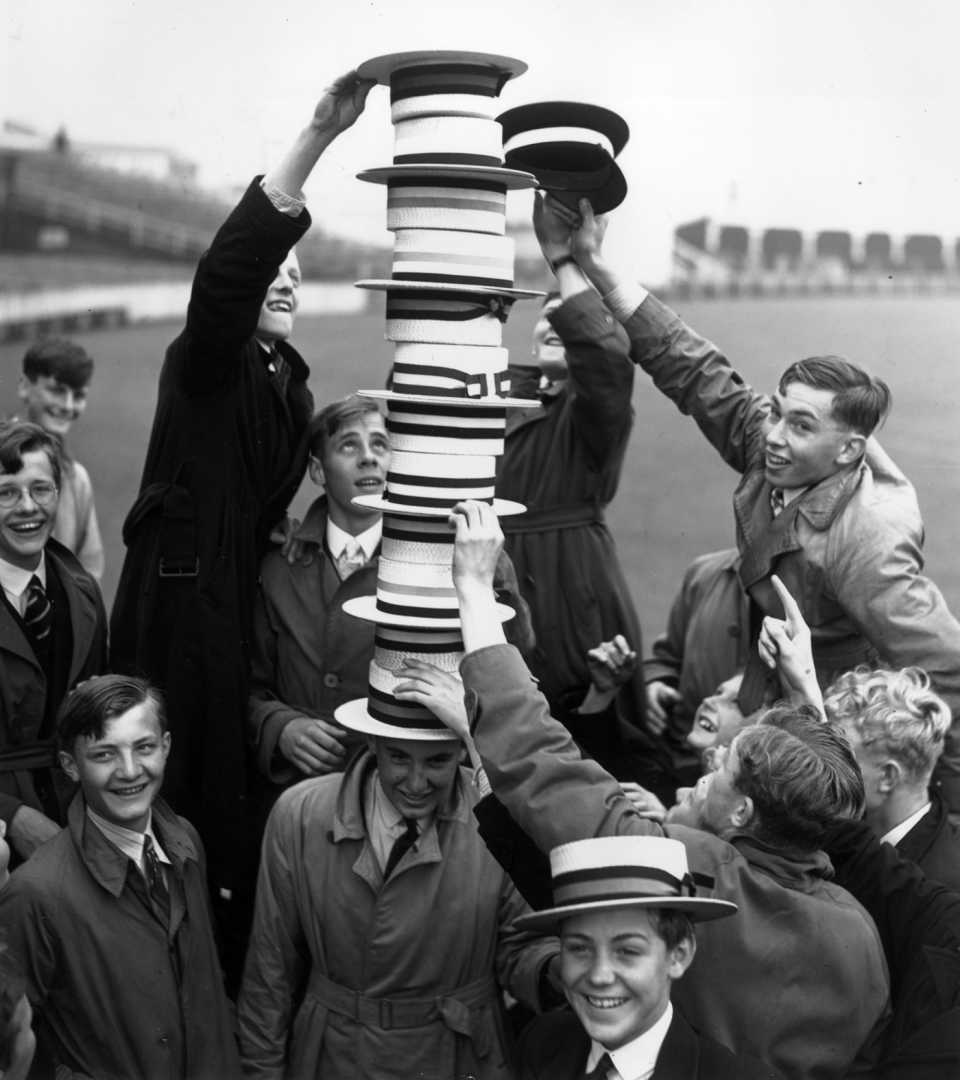 Young spectators entertain themselves during the tea break by building a hat tower