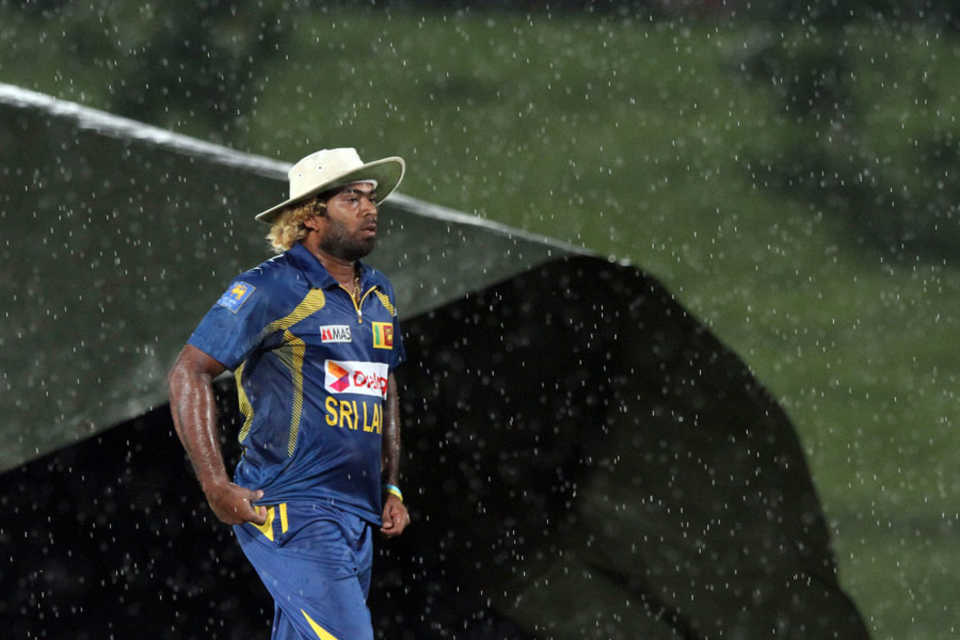 Lasith Malinga walks off the ground as the covers come on