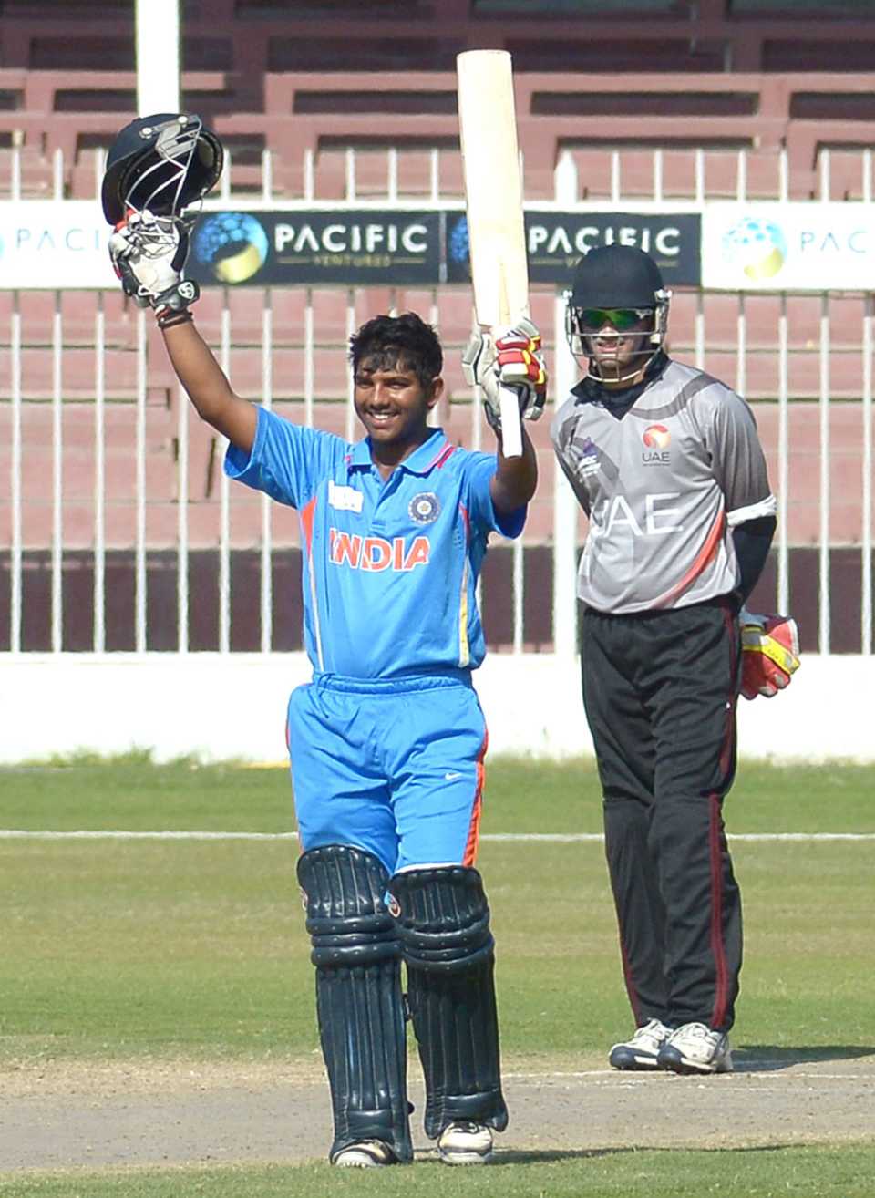 Akhil Herwadkar raises his bat after scoring a century