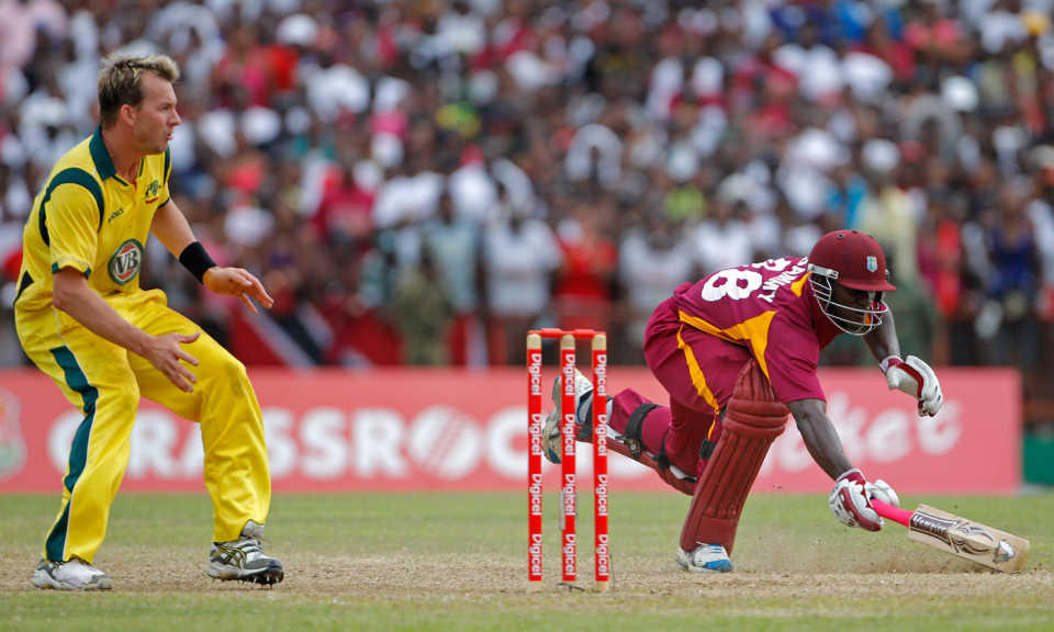 Darren Sammy dives into the crease while Brett Lee waits for the ball