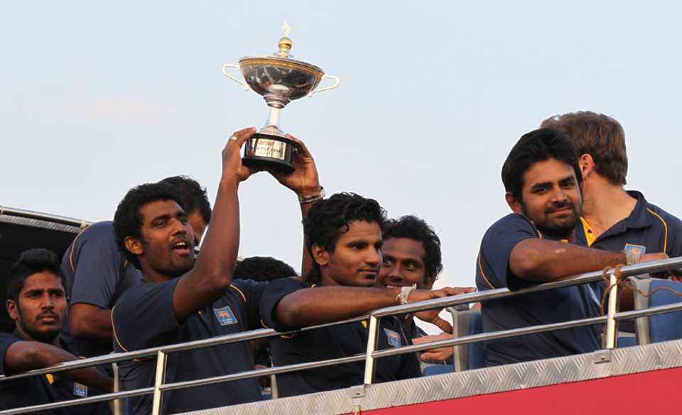 Thisara Perera hoists the Asia Cup into the air on an open-top bus, Colombo, March 9, 2014