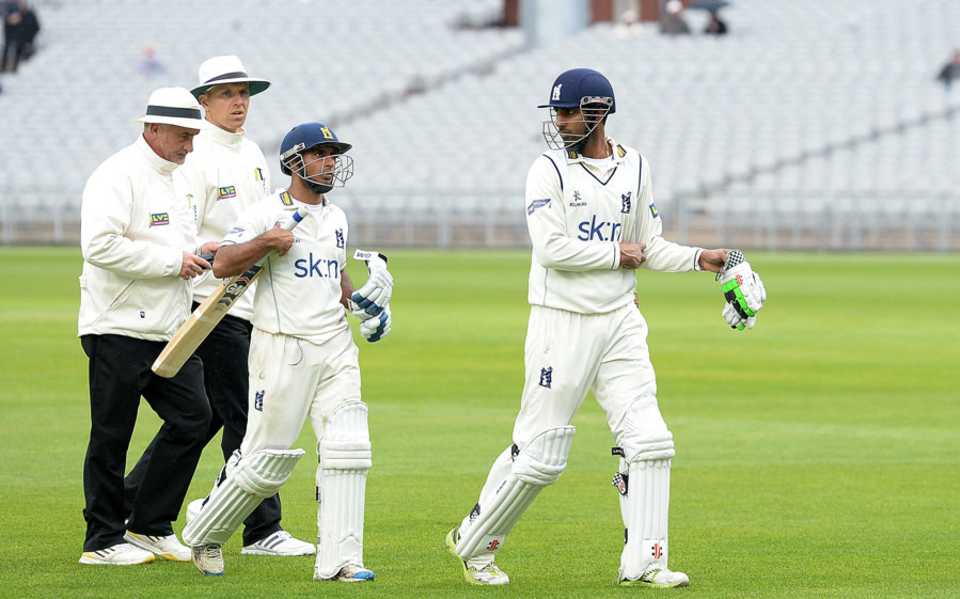 Ateeq Javid and Varun Chopra head off after the umpires halted play due to bad light