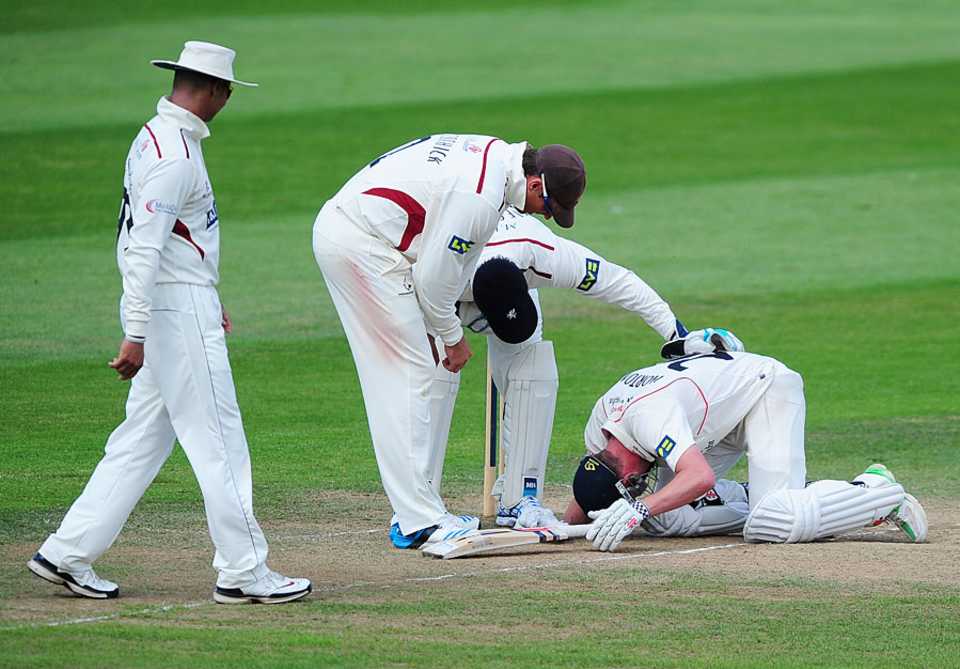 Somerset players show their concern for Paul Horton after a blow which forced him to retire hurt