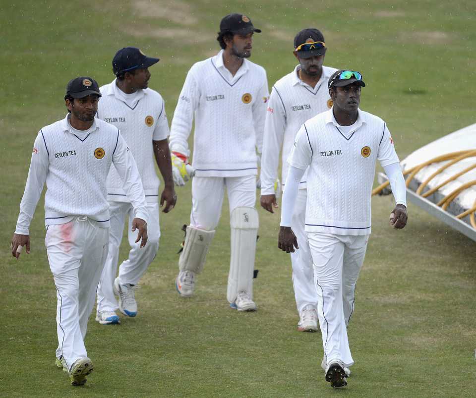 The Sri Lankan players leave the field after rain intervenes