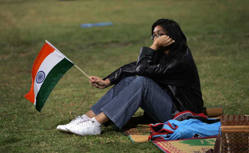 An Indian fan waits for the rain-delayed match to begin
