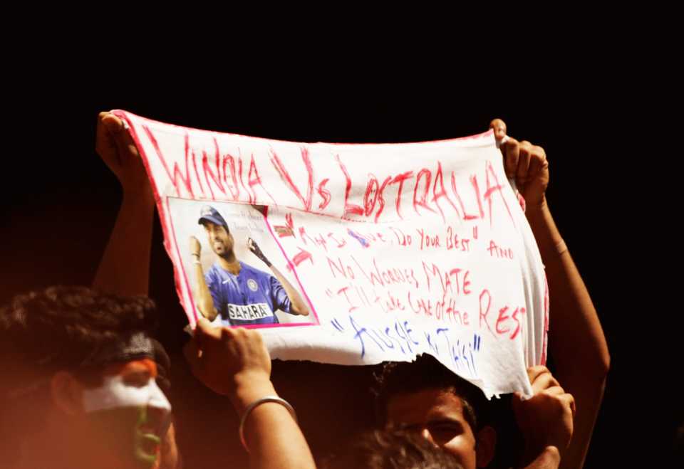 An Indian fan holds up a banner