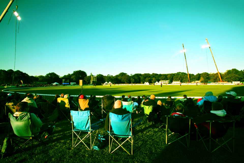Spectators watch the T20 under temporary lights