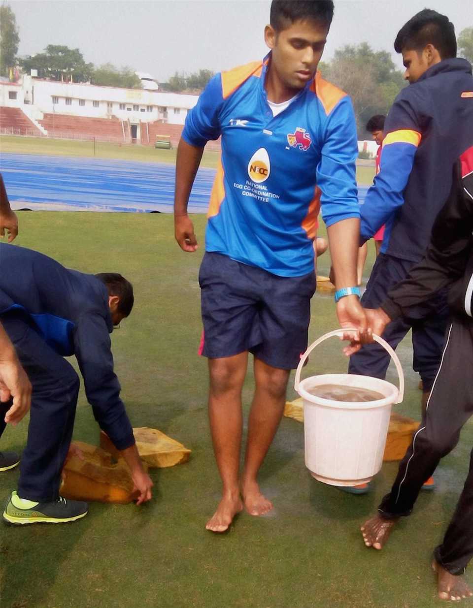 Suryakumar Yadav helps in clearing water from the ground, Railways v Mumbai, Ranji Trophy, Group A, 2nd day, Delhi, December 15, 2014
