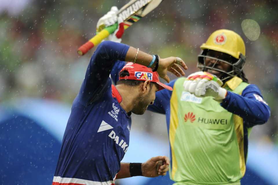 Yuvraj Singh and Chris Gayle share a light moment as the teams leave the field