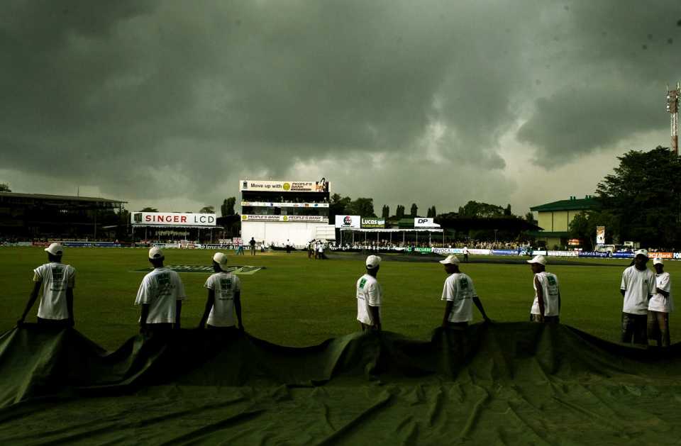 The groundstaff prepare to bring the covers on 
