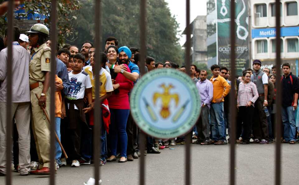 Fans wait queue to enter the Chinnaswamy Stadium for the India-Pakistan T20