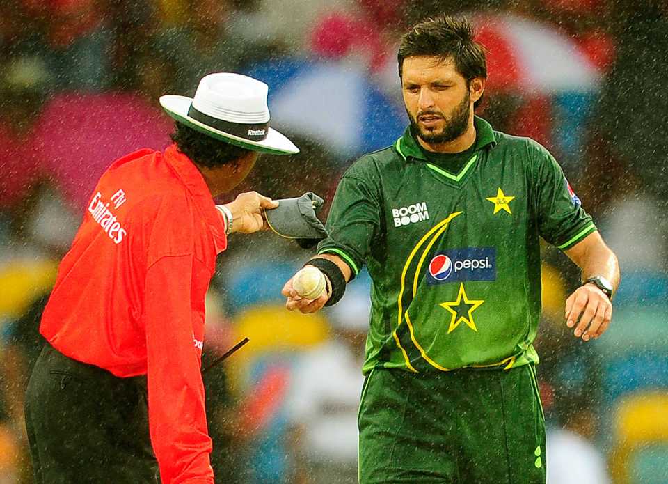 Shahid Afridi hands Asoka de Silva the ball as rain interrupts the game