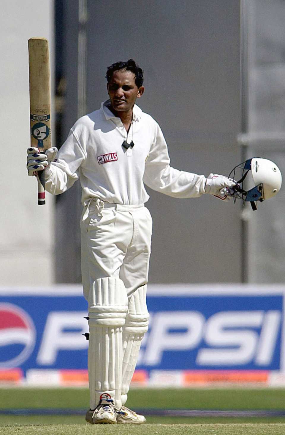 Azharuddin raises his bat after completing his century on his comeback into the Indian team