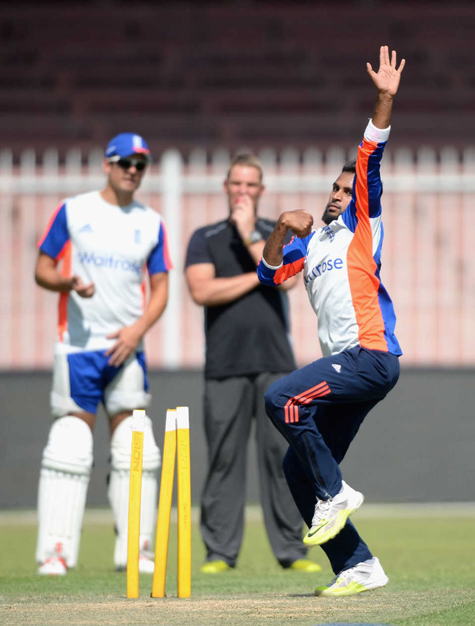 Adil Rashid bowls in the nets at Sharjah, watched by Alastair Cook and Shane Warne