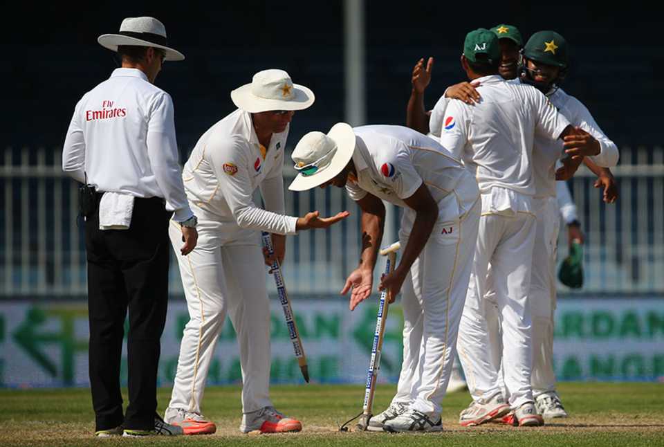Pakistan's fielders grab souvenir stumps after wrapping up victory in Sharjah