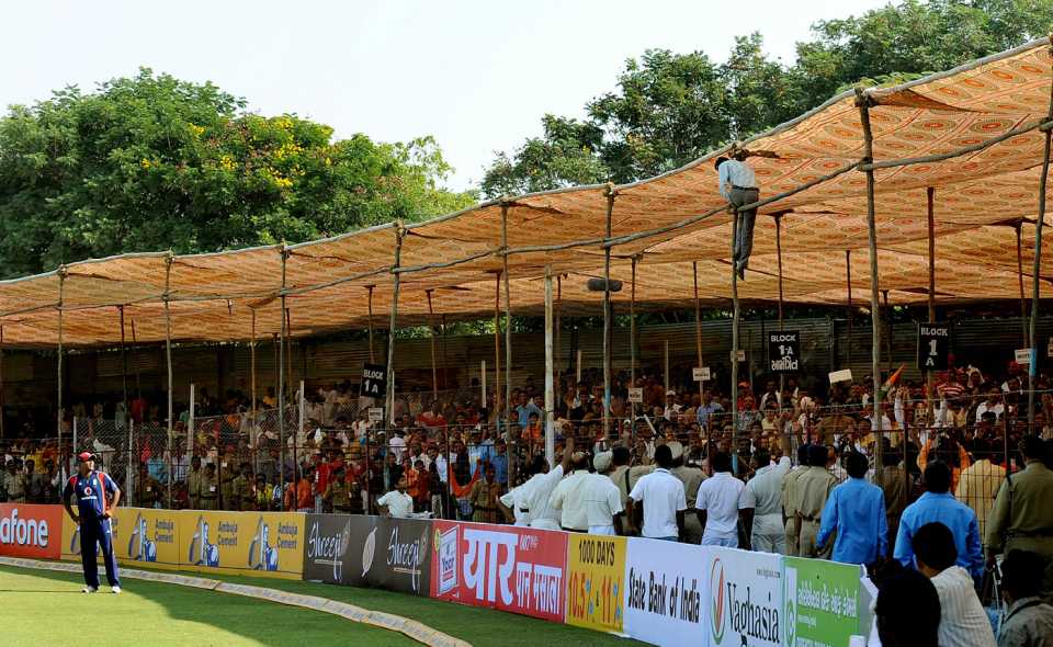 A fan climbs on to the scaffolding after a six was hitonto the roof of the canopied stand, India v England, 1st ODI, Rajkot, November 14, 2008