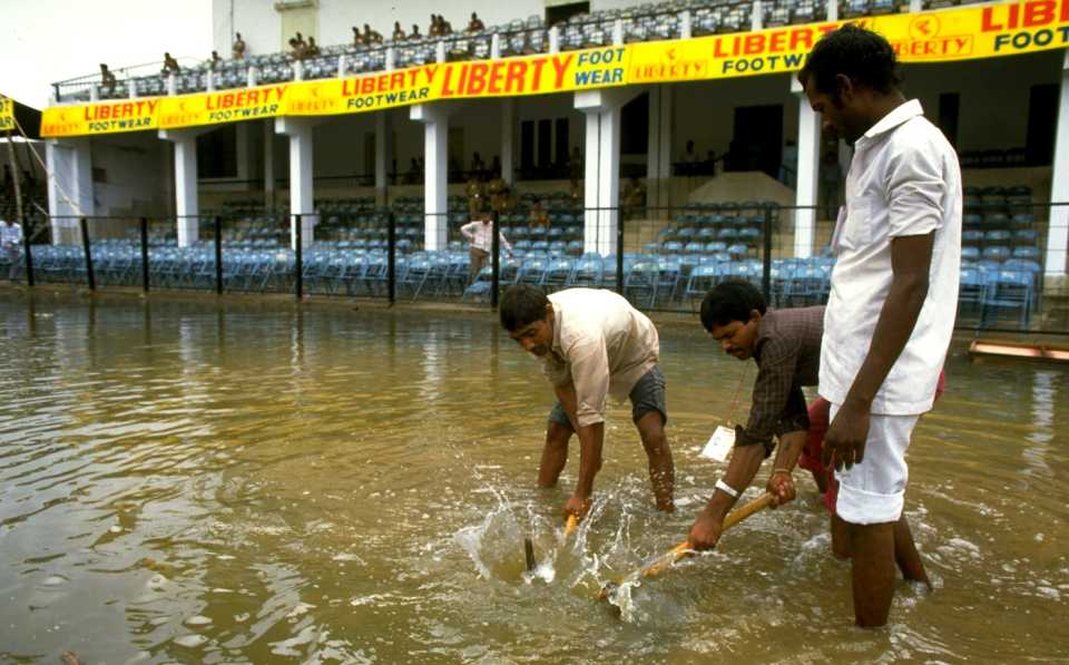 Ground staff deal with a flooded ground