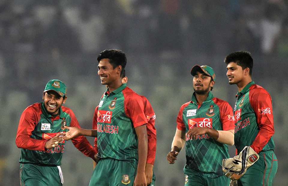 The Bangladesh team gather around Mustafizur Rahman after the win