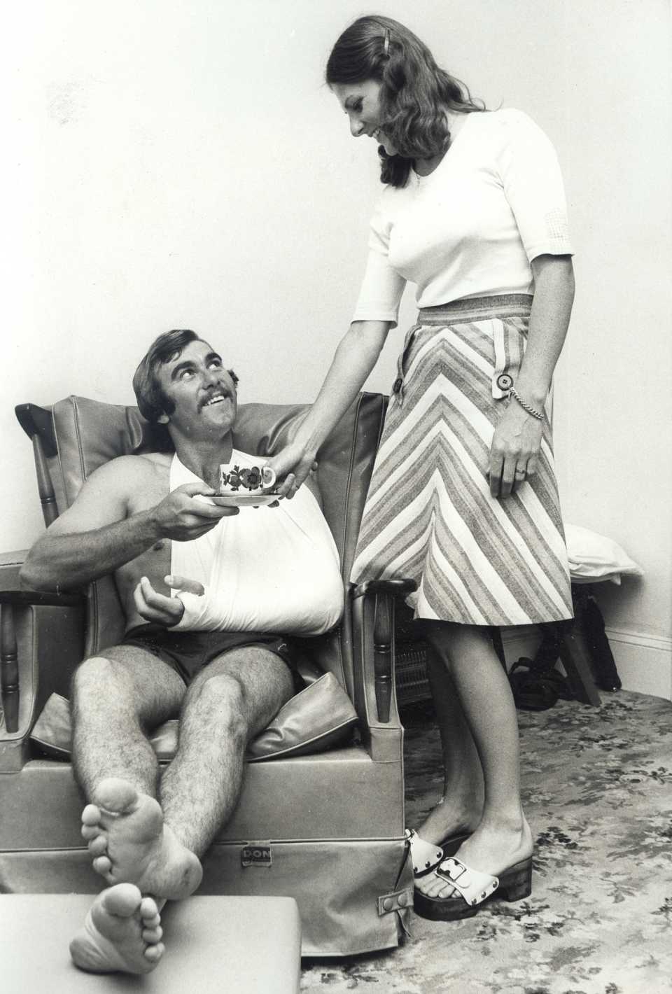 New South Wales opener Len Richardson, whose arm was broken by a Jeff Thomson delivery, gets a cup of coffee from his sister Margaret at their parents' home in Paddington