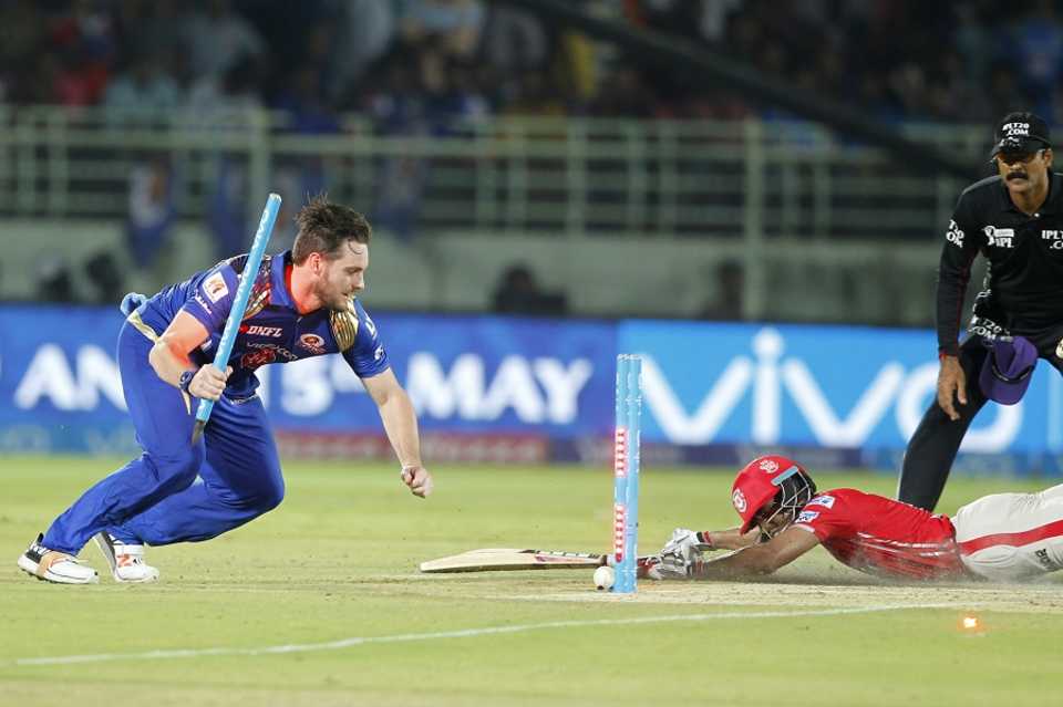 Mitchell McClenaghan uproots the stumps as he tries to run Wriddhiman Saha out