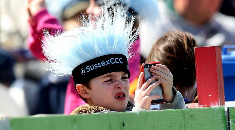 A young fan looks at his phone