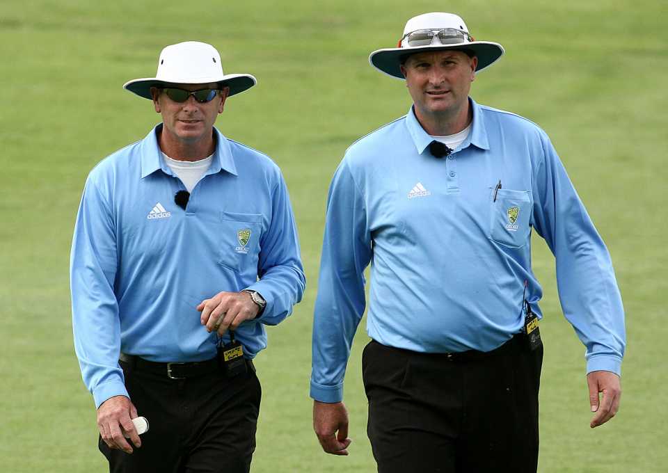 The umpires Paul Reiffel and Paul Wilson leave the field