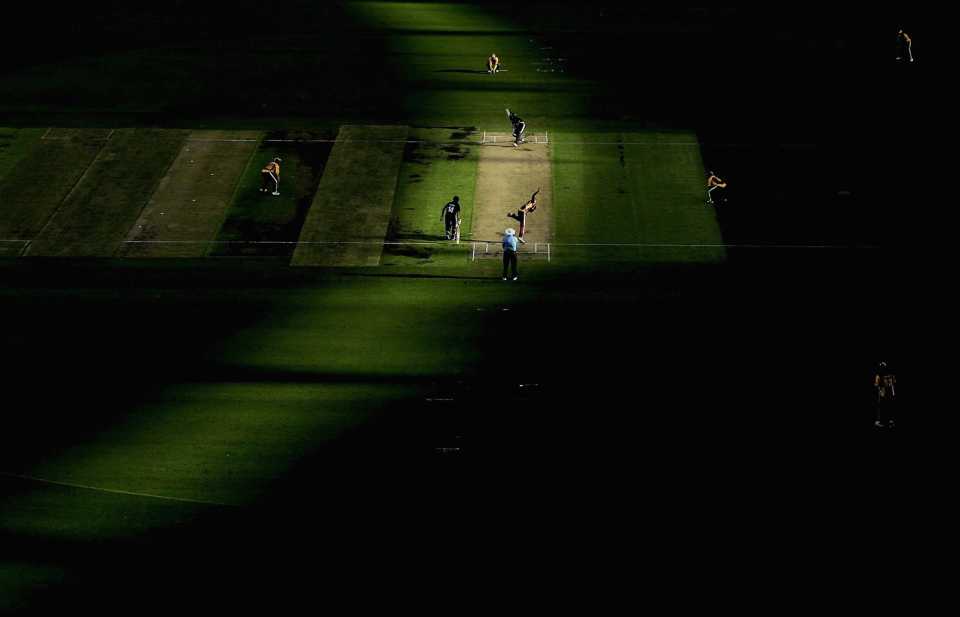 A strip of sunlight falls on the pitch amid shadows