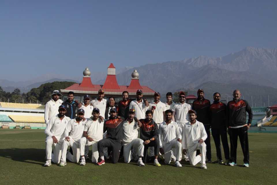 Madhya Pradesh's players pose against a scenic backdrop