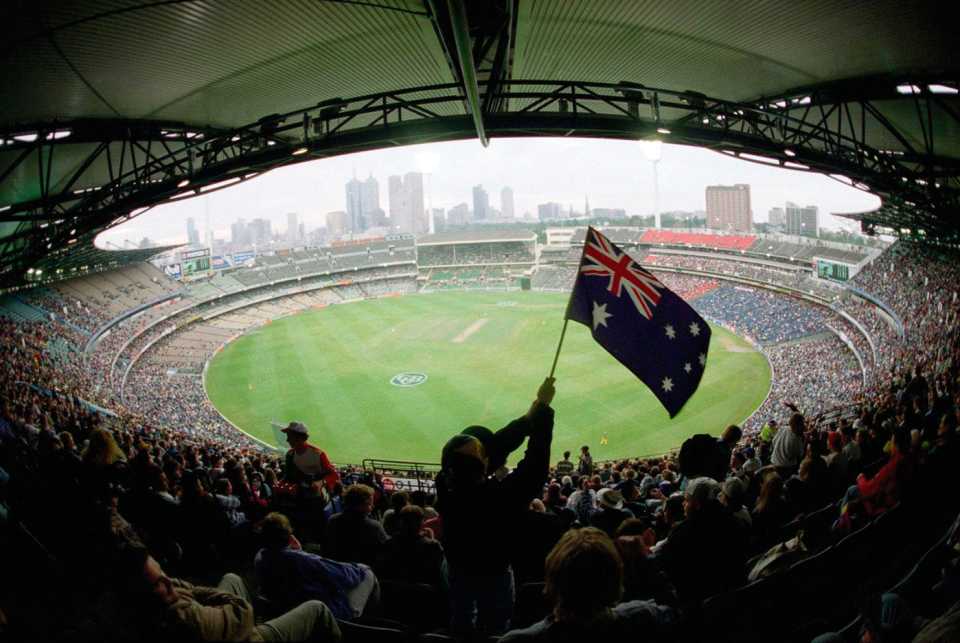 A fan waves the Australian flag high up in the stands