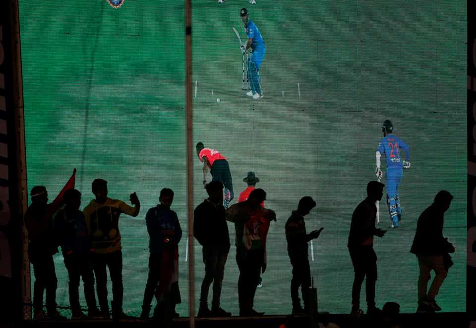 Spectators stand in front of the big screen in Kanpur