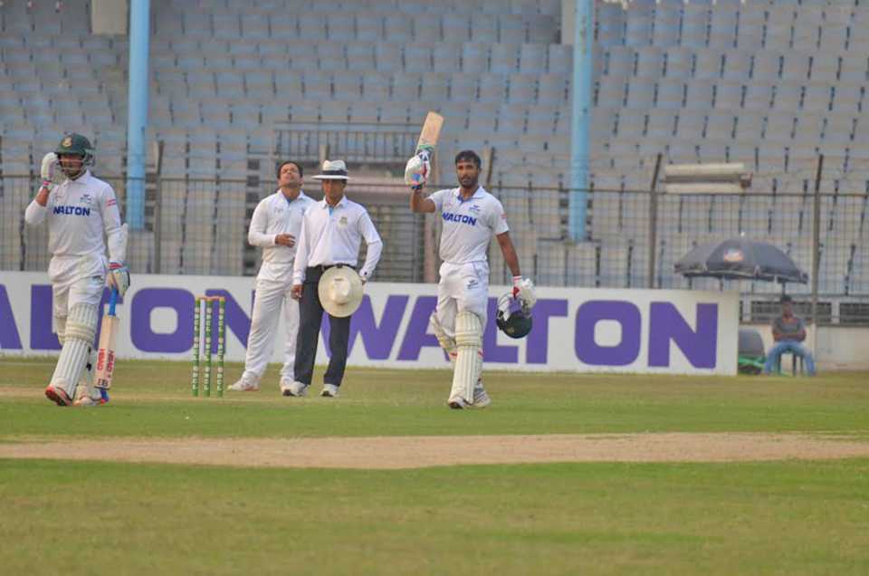 Shuvagata Hom raises his bat after reaching his century