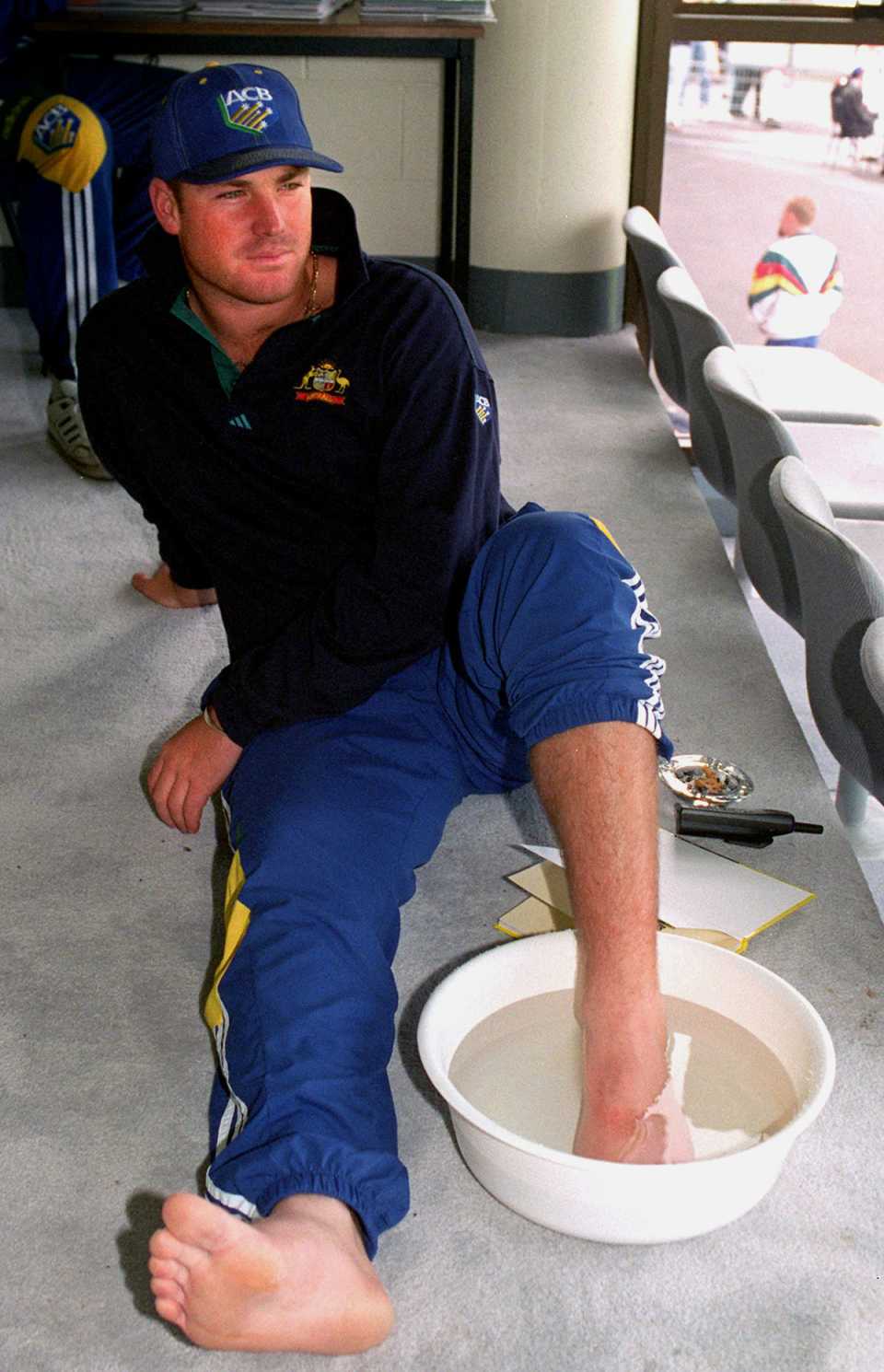 Shane Warne soaks his foot in a tub of water after receiving a cracked toe while batting