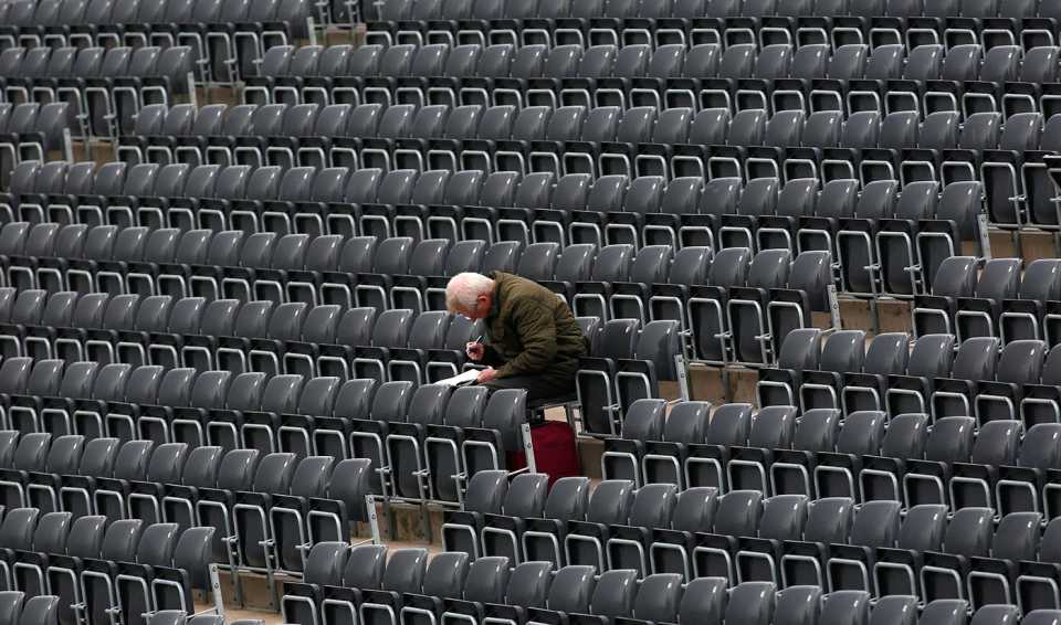 A spectator works on a crossword puzzle