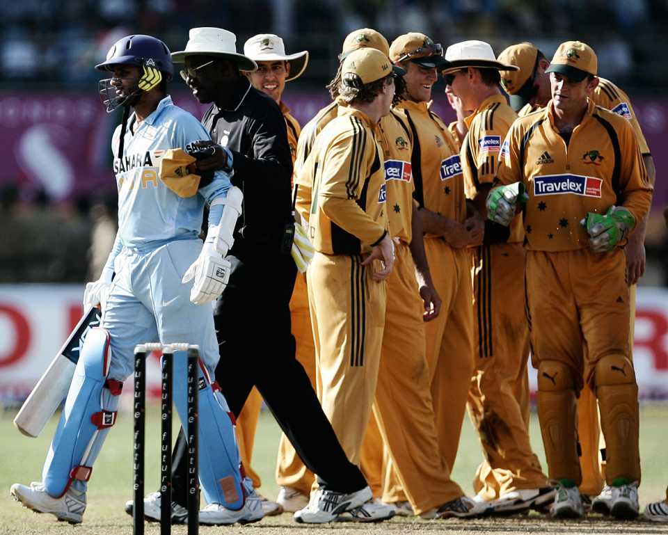 Umpire Steve Bucknor leads Harbhajan Singh away after the batsman got into an argument with the Australians