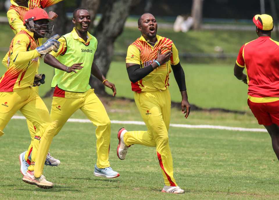 Uganda captain Roger Mukasa sprints off after taking the final wicket to secure victory