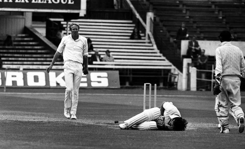 Dayle Hadlee lies on the ground after being struck by a delivery by Tony Greig