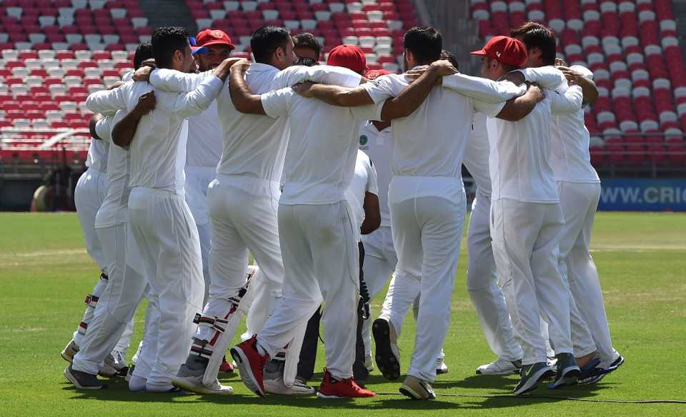The Afghanistan players get into a huddle after recording their first Test win, Afghanistan v Ireland, Only Test, Dehradun, 4th day, March 18, 2019