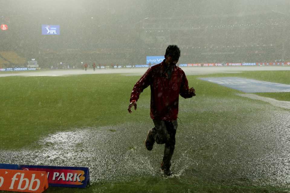 A member of the groundstaff gets drenched in Bengaluru