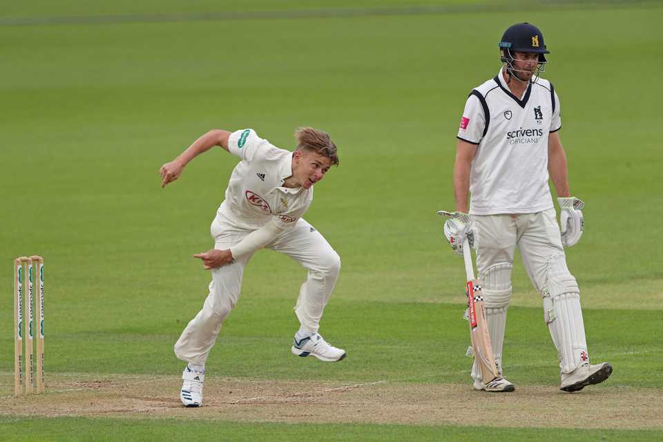 Sam Curran of Surrey bowls as Warwickshire's Dominic Sibley looks on 