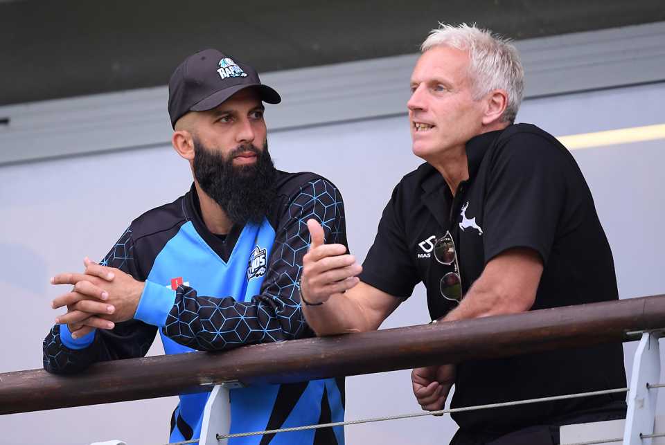 Moeen Ali and Peter Moores talk during a rain delay