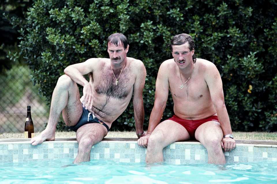 Dennis Lillee and Ian Botham relax by the side of a swimming pool at a winery on the rest day of the Adelaide Test
